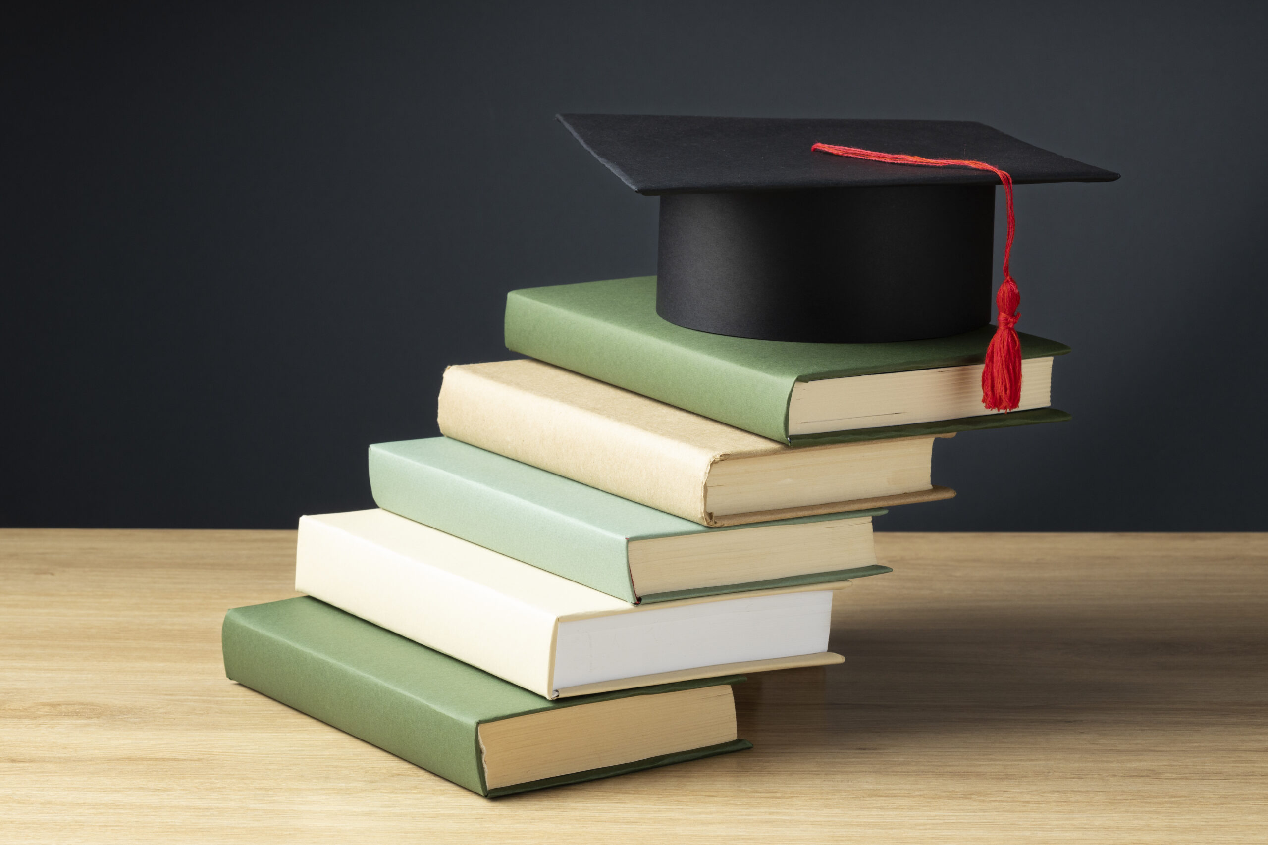 high-angle-books-graduation-cap-education-day